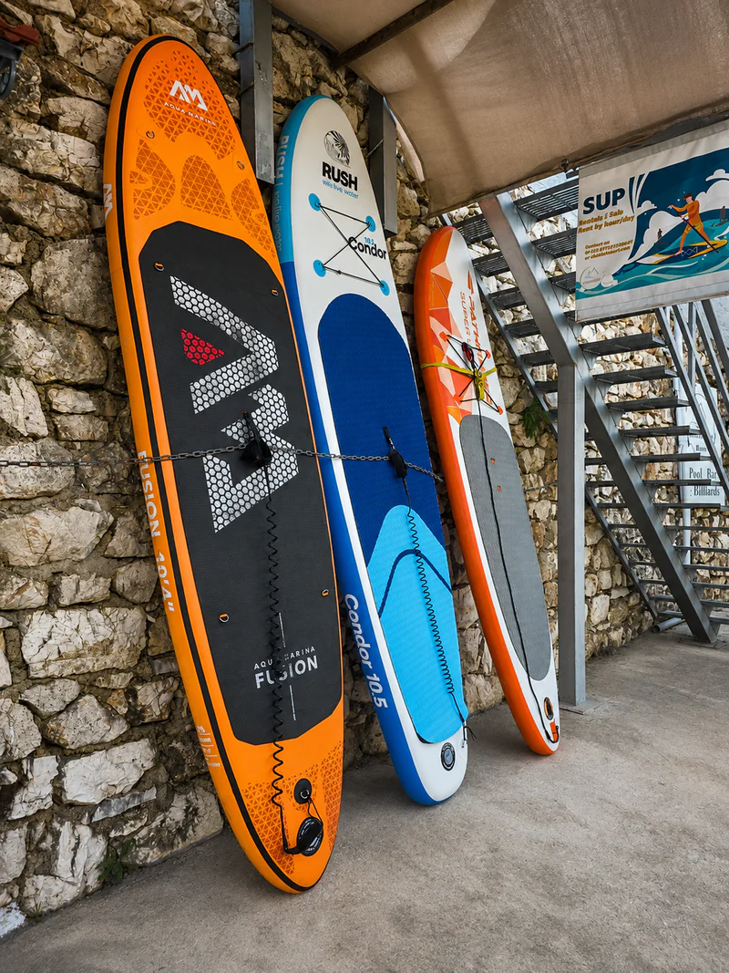 Stand-up paddleboards ready to rent for exploring sheltered Geni Bay