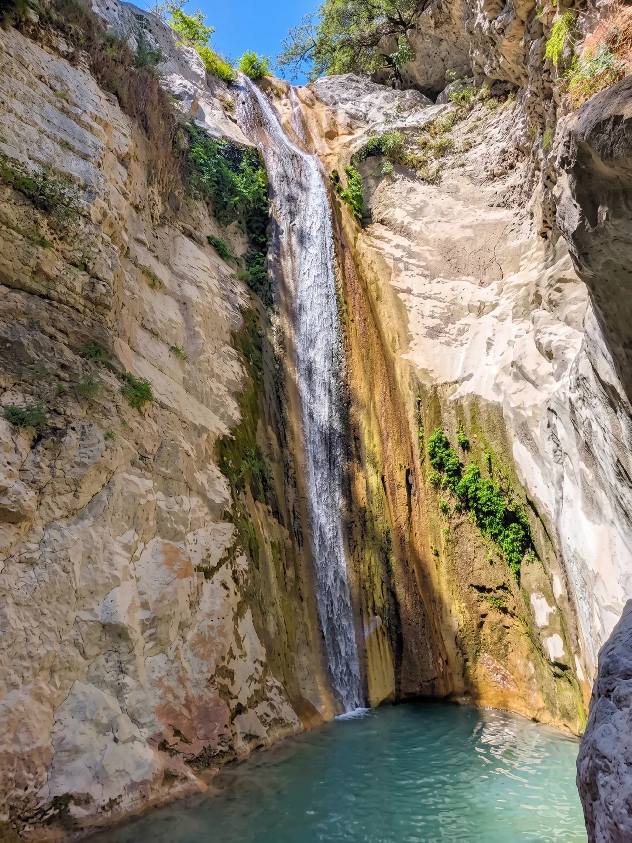 Dimosari Waterfalls cascading into a turquoise pool in the gorge near Nidri, Lefkada
