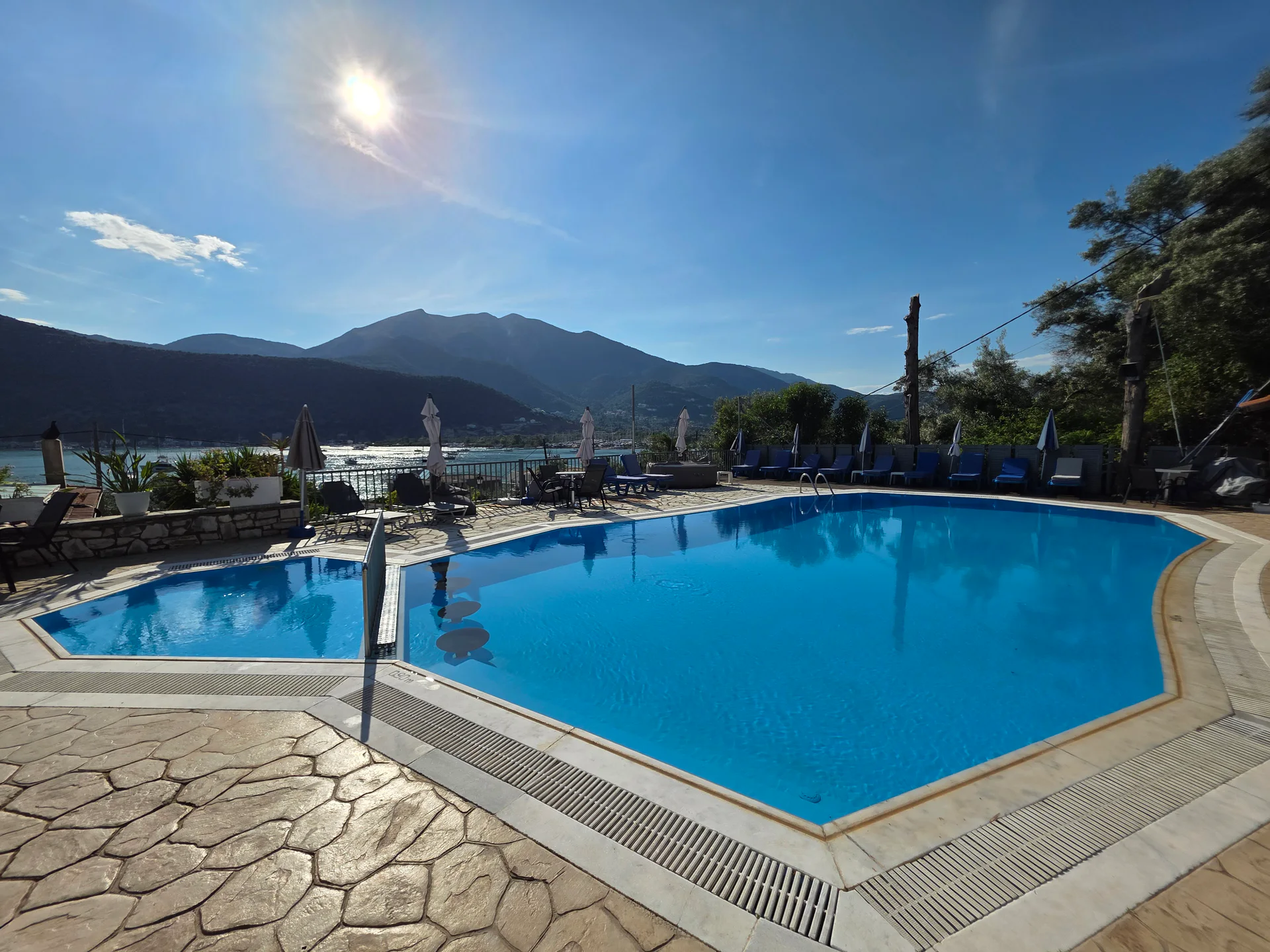 The outdoor pool at Chakalaka Resort with Geni Bay and green mountains