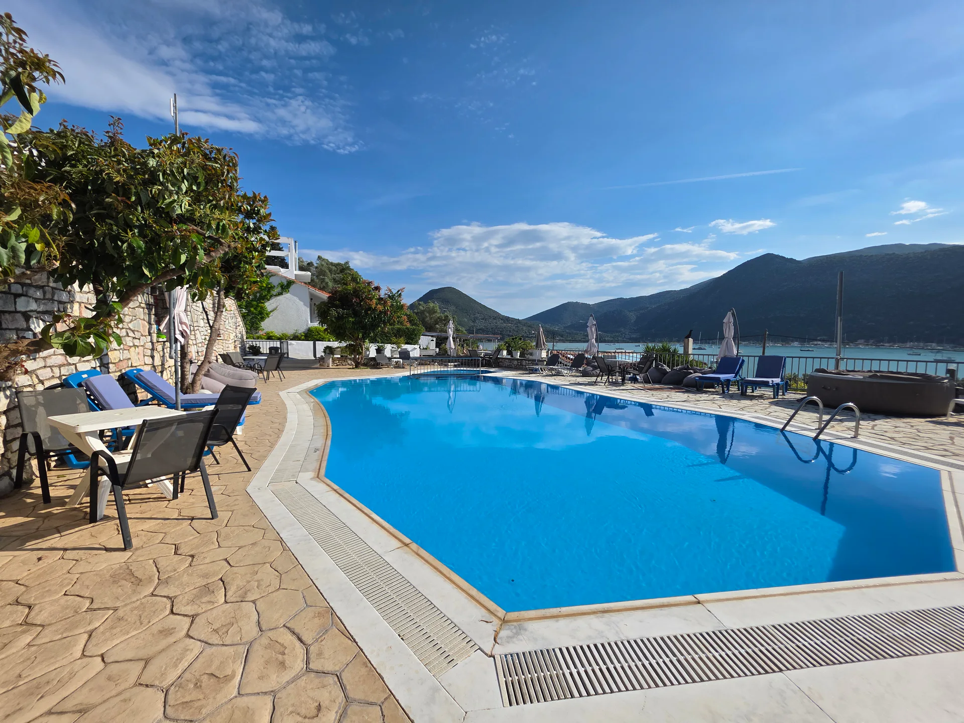 The outdoor pool at Chakalaka Resort with Geni Bay and green mountains