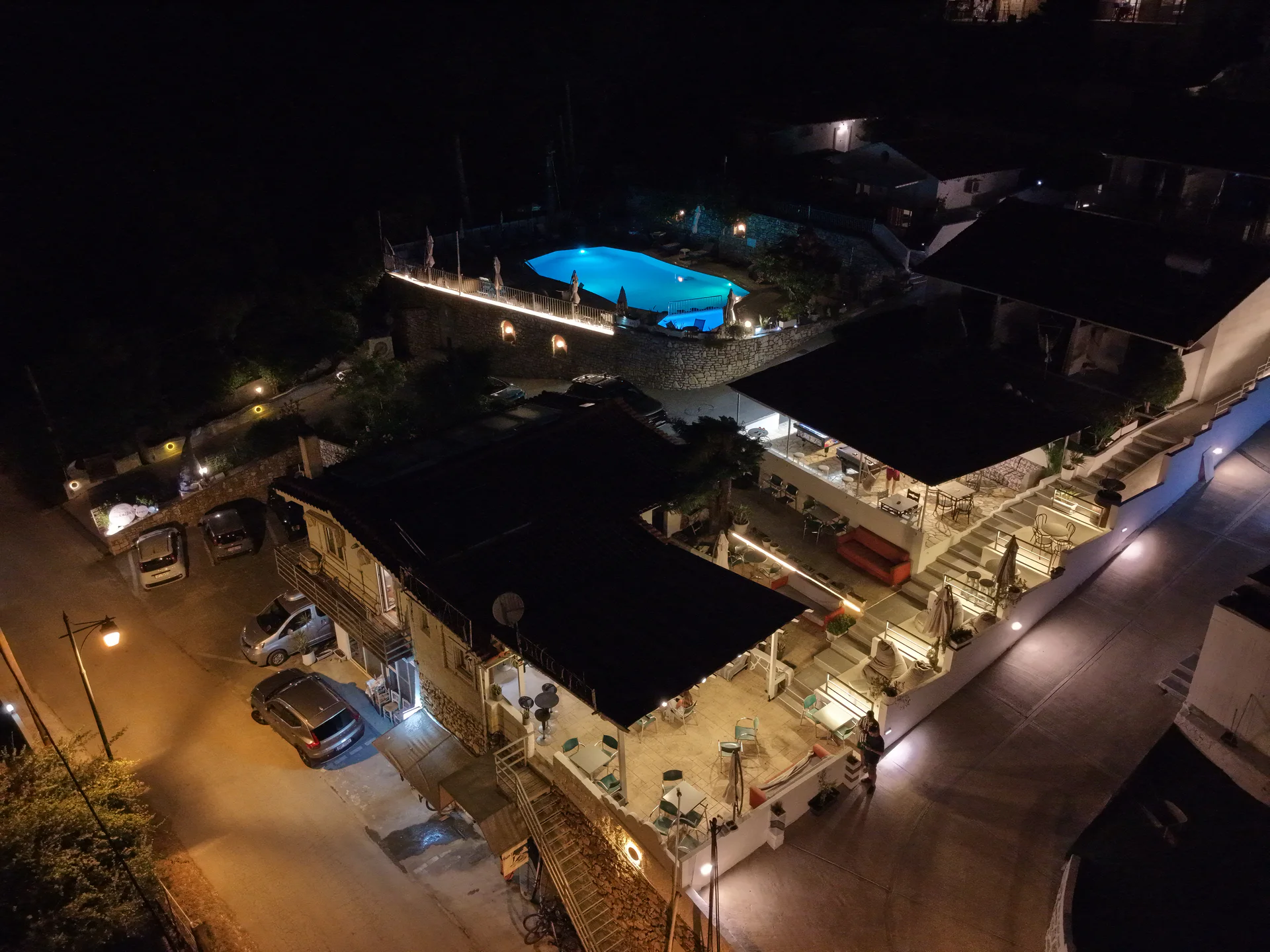 Chakalaka Resort, its terraces and illuminated pool seen from above at night